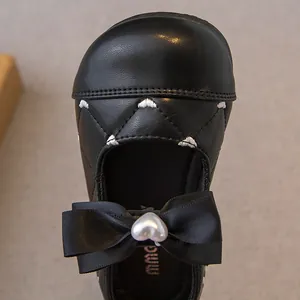 Elegante zwarte Mary Jane schoenen voor meisjes met zijden strik en hartparel detail.