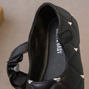 Detailweergave van zwarte gewatteerde prinsessenschoenen voor meisjes met hartborduursel