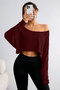 Mirror selfie view of a burgundy long-sleeved one-shoulder crop top with loose fit.