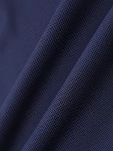 Nahaufnahme von marineblauem, atmungsaktivem Mesh-Gewebe mit Wabenstruktur.