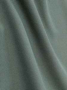 Nahaufnahme der Textur von hochwertigem olivgrünem Waffelstrickstoff im Detail