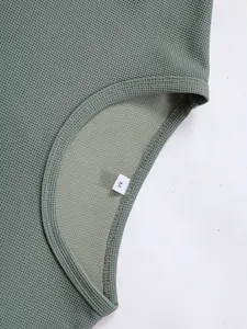 Nahaufnahme des salbeigrünen Waffelstrick-Oberteils mit Detail des M-Größenetiketts.