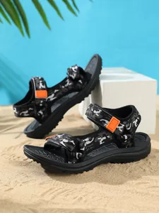 Stylish kids camouflage beach sandals with anti-slip soles displayed on sunny sand background