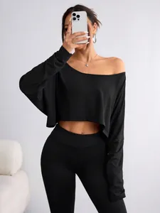 Elegant black one-shoulder long sleeve crop top paired with slim fit high waist leggings