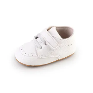 Detailed view of classic white baby walking shoes with textured leather and velcro