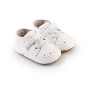 Close-up detail of white baby walking shoes with velcro straps and soft leather texture