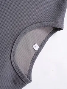 Detailansicht graues Herren-Sportoberteil mit M-Größenetikett und Textur