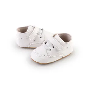 Detailed view of white faux leather pre-walker baby shoes with adjustable velcro strap