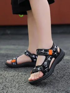 Detailed side view of children's non-slip camouflage sandals with vibrant orange accents