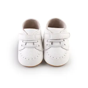 Detailed view of white faux-leather baby walking shoes with Velcro strap closure