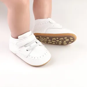 Detailed view of white infant pre-walker shoes featuring non-slip soles and a Velcro strap
