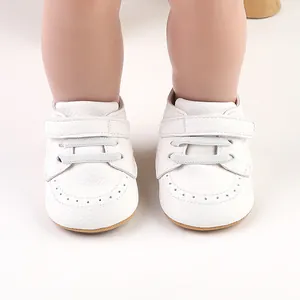 Detail showing white baby walking shoes with hook-and-loop closure and soft leather texture