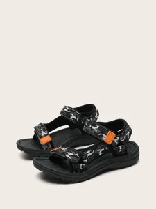 Side view of children's sporty sandals with black camouflage pattern and orange buckles