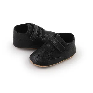 Detailed view of black faux leather baby shoes with soft soles and velcro straps