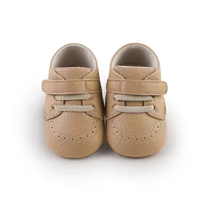 Detailed view of tan faux leather baby walking shoes with velcro strap and stitching.