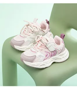 Detailansicht der atmungsaktiven rosa-weißen Sportschuhe für Mädchen auf einem grünen Stuhl