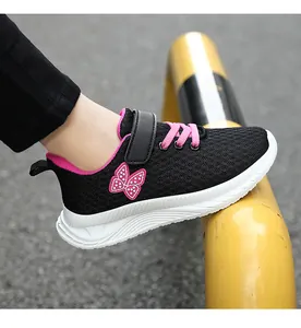 Dettaglio di sneaker da bambina in mesh nero con farfalla rosa e lacci