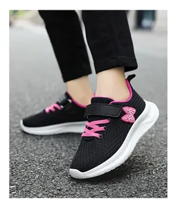 Dettaglio di scarpe da ginnastica in mesh nero per bambine con farfalla rosa.