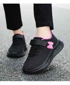 Dettaglio di scarpe sportive da bambina in mesh traspirante nero con farfalla rosa