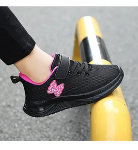 Dettaglio scarpa sportiva nera da bambina in mesh traspirante con farfalla rosa