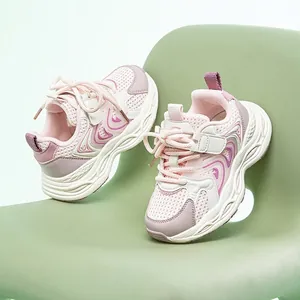 Atmungsaktive rosa und weiße Mesh-Dad-Sneaker für Kinder auf einem hellgrünen Stuhl