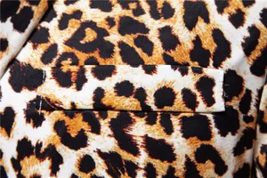 Close-up of leopard print suit jacket showing fabric texture and pocket detail.