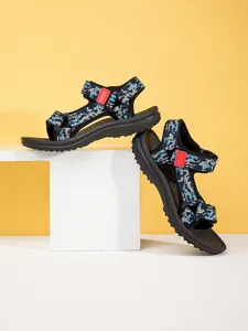 Side view of children's non-slip beach sandals with houndstooth patterned straps on white block.