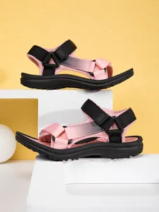 Side view detail of pink children's sandals with black adjustable straps and non-slip sole