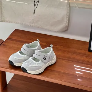 Gedetailleerd zijaanzicht van grijze mesh baby wandelschoenen op een houten plank