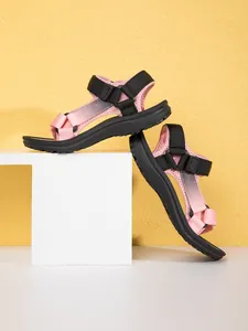 Detailed side view of pink and black children's non-slip beach sandals on geometric prop