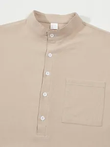 Detailansicht eines beigen Baumwoll-Leinen-Henley-Hemdes mit Stehkragen und Tasche
