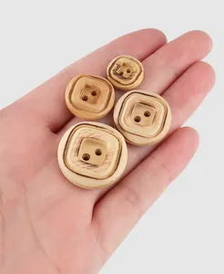 High-quality detail of natural poplar wood buttons with decorative pattern in hand