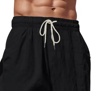 Dettaglio ravvicinato dei pantaloni in lino nero da uomo con elastico in vita e coulisse.