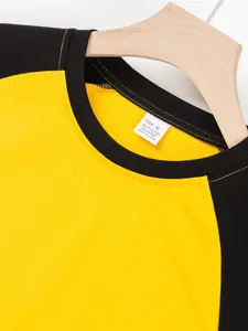 Detail view of the ribbed collar and material of a yellow and black raglan sleeve T-shirt.