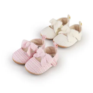 Detail von rosa und cremefarbenen Baby-Prinzessin-Schuhen mit Plüschschleife.