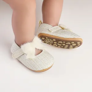 Detailansicht von Baby-Prinzessin-Lauflernschuhen mit flauschiger Schleife und Gummisohle.