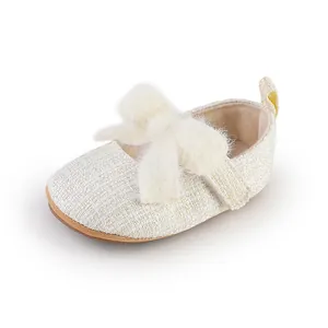 Nahaufnahme von cremefarbenem Tweed-Babyschuh für Mädchen mit großer flauschiger Schleife.