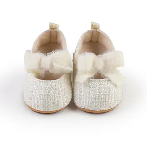 Detailansicht cremefarbene Baby-Prinzessinenschuhe mit flauschiger Schleife und Webstoff
