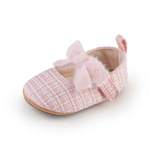 Detailansicht eines rosa Tweed-Babyschuhs mit einer dekorativen weichen Plüschschleife.