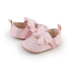 Detaillierte Nahaufnahme der rosa Tweed-Babyschuhe für Mädchen mit weicher Schleife