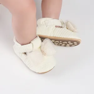 Detail view of cream baby walking shoes with mesh bow and corduroy texture.