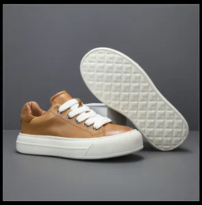 Vue détaillée de baskets en cuir marron pour hommes avec semelle blanche épaisse et dessous.