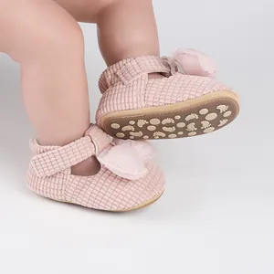 Pink textured baby walking shoes with bow detail and non-slip footprint patterned sole