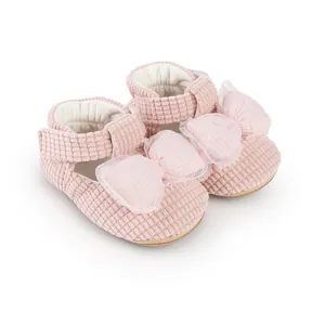 Detailed shot of pink corduroy baby walking shoes with a delicate tulle bow