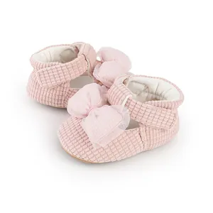 Close-up of pink baby pre-walker shoes featuring corduroy texture and a large mesh bow detail