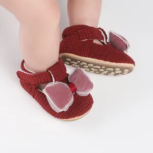 Detailed view of burgundy corduroy baby walking shoes with white mesh bow decoration