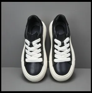 Vue de dessus détaillée de baskets en cuir noir pour hommes avec semelles blanches