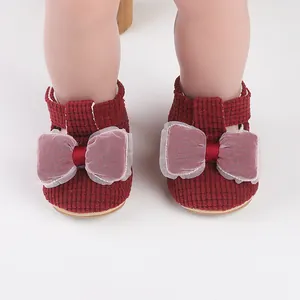 Close-up view of cute red baby pre-walker shoes with elegant mesh bow decoration
