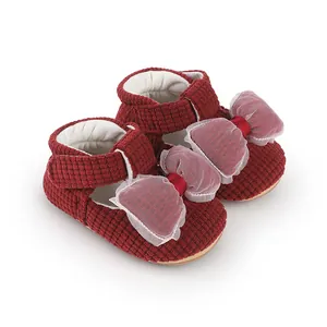 Adorable red corduroy baby walking shoes featuring a large decorative soft tulle bow