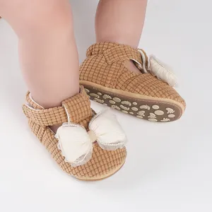 Detailed view of baby walking shoes featuring a white bow and anti-slip soft sole